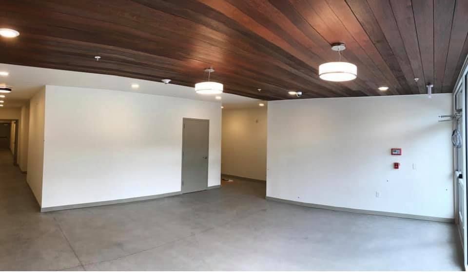 A large empty room with a wooden ceiling and white walls.