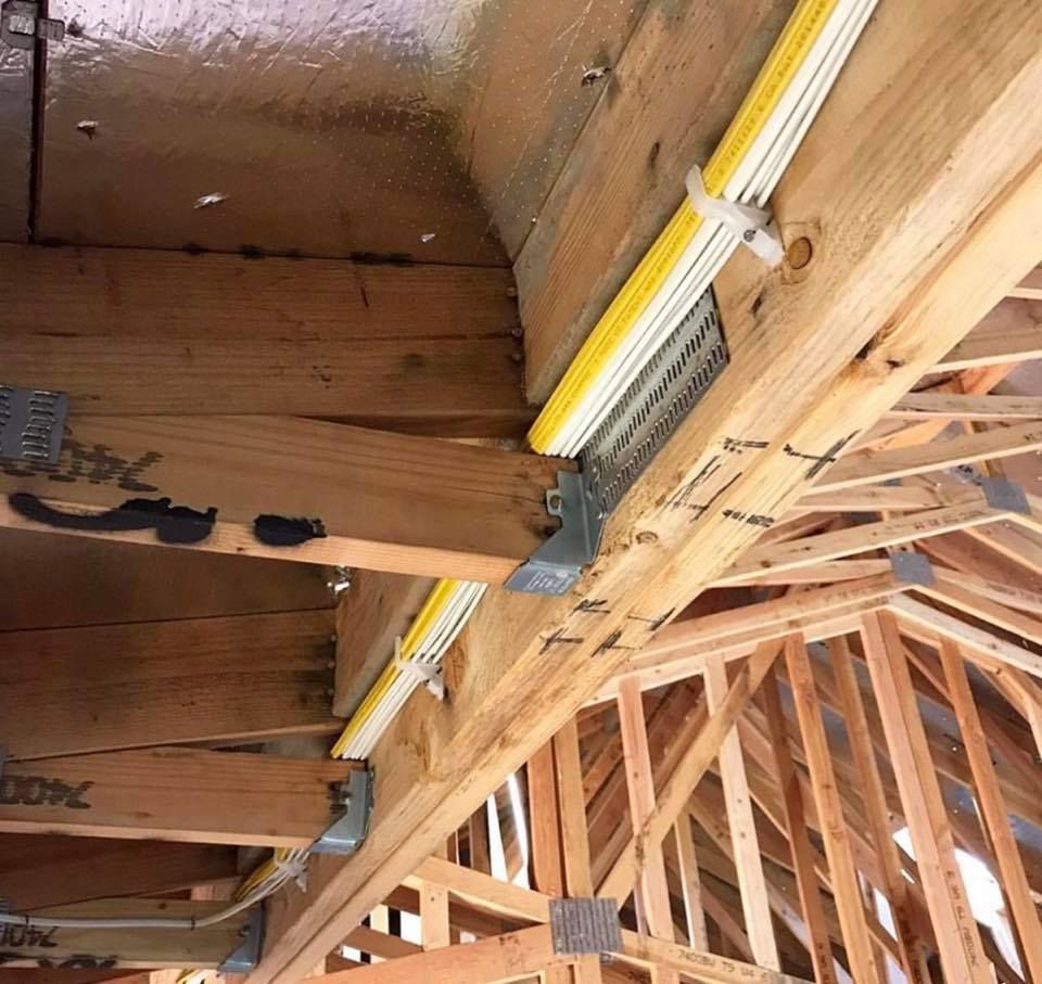 The ceiling of a building under construction with a yellow light hanging from it