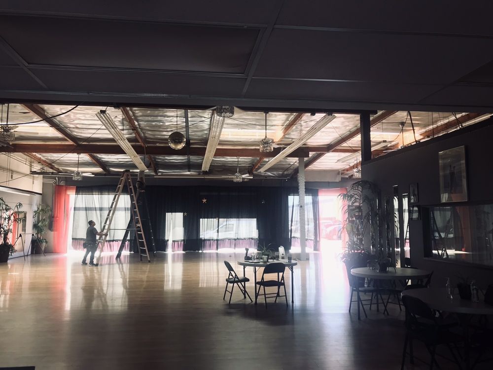 A large empty room with tables and chairs in it.