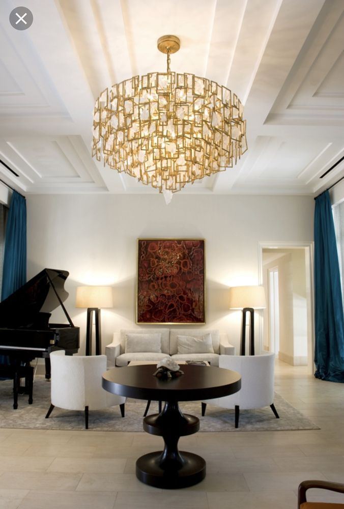 A living room with a piano and a chandelier