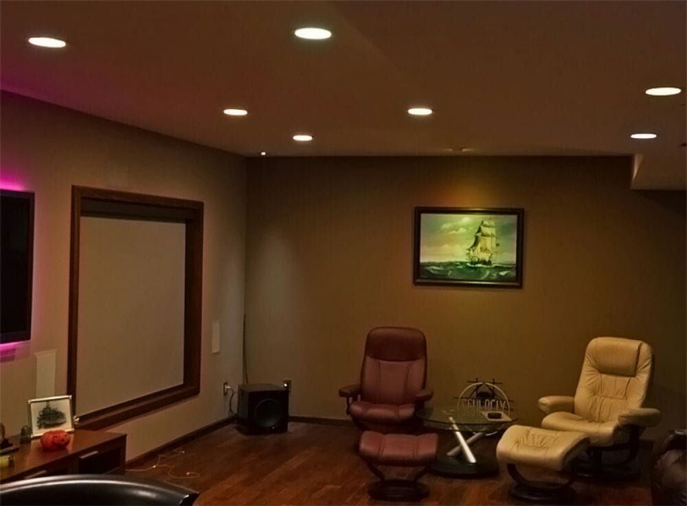 A living room with two chairs and a projector screen