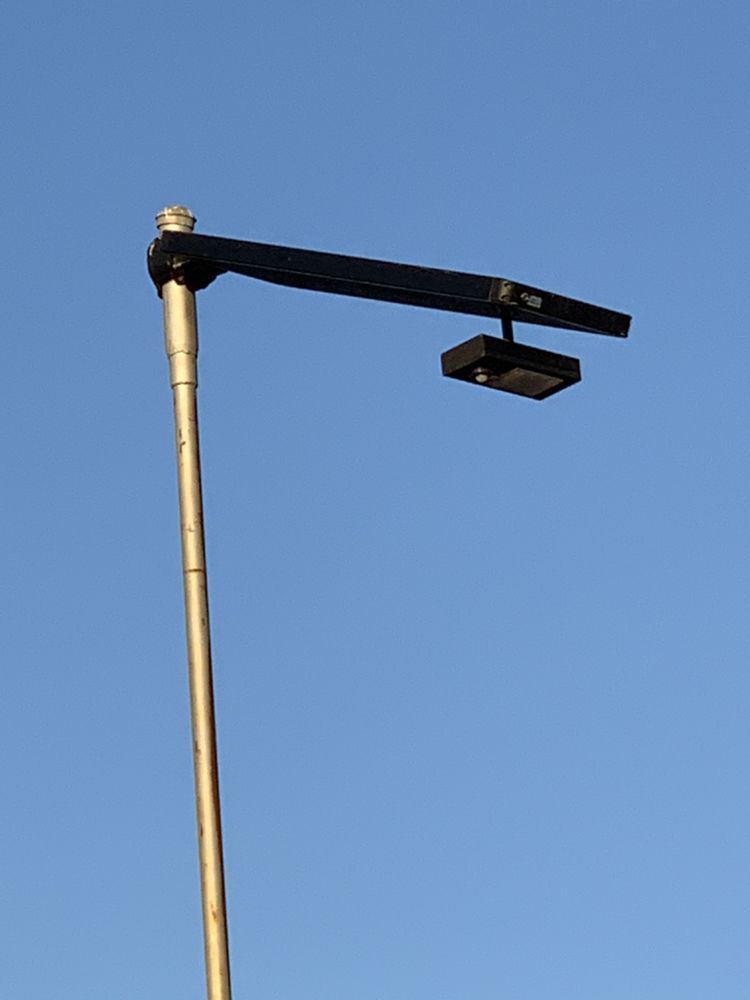 A street light on a pole with a blue sky in the background