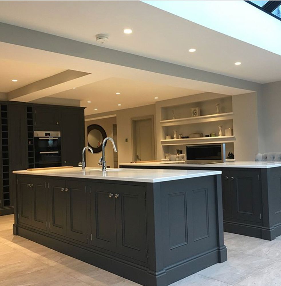 A kitchen with black cabinets and white counter tops