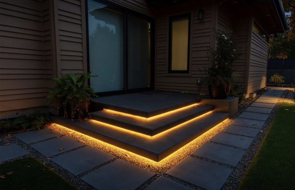 A house with stairs that are lit up at night.