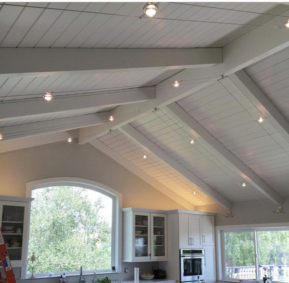 A kitchen with white cabinets and a vaulted ceiling