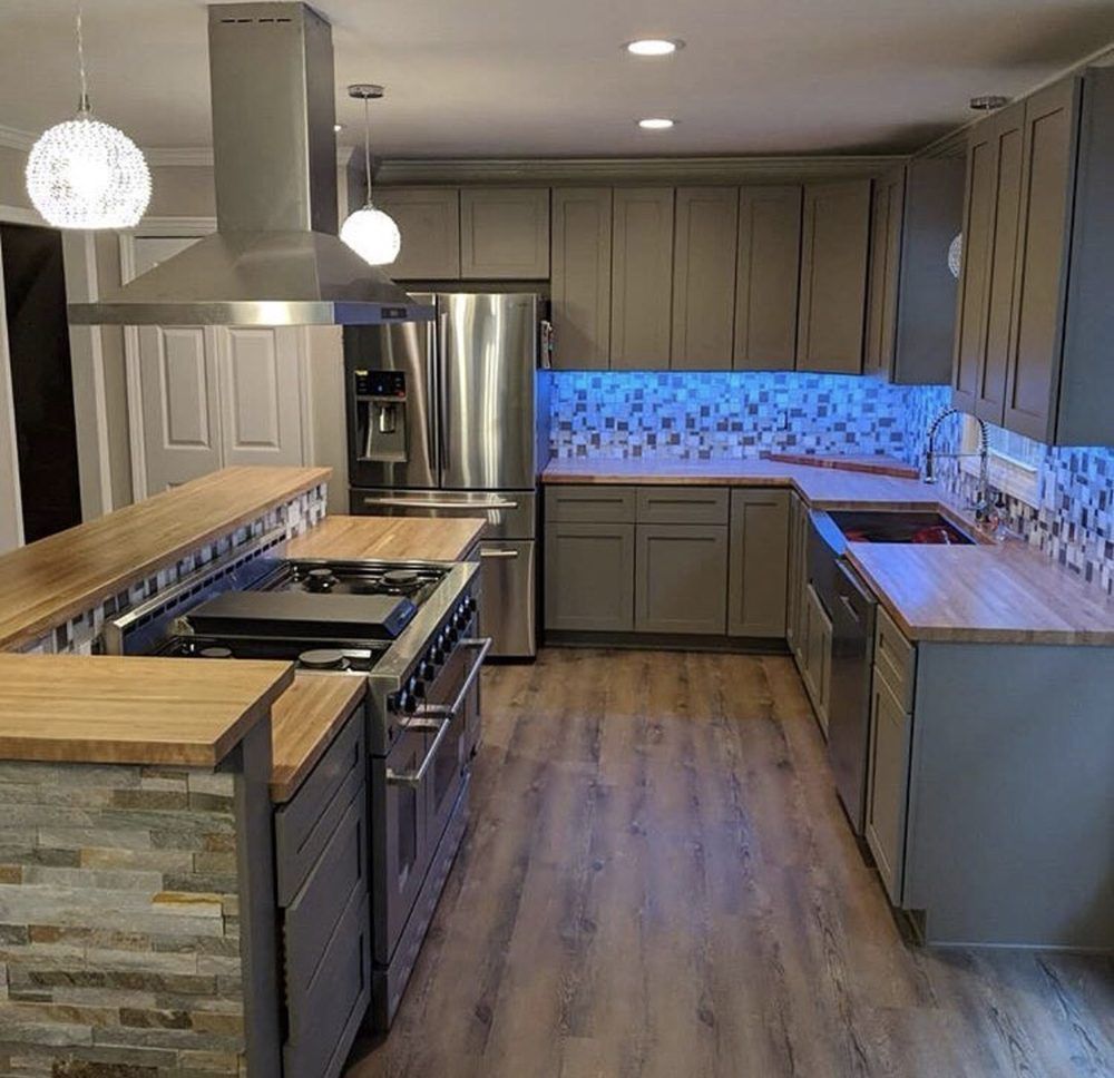 A kitchen with gray cabinets and stainless steel appliances