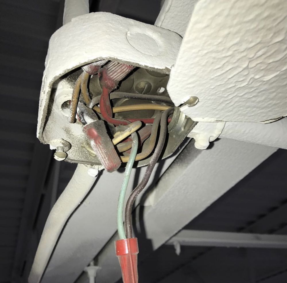 A bunch of wires are hanging from a ceiling