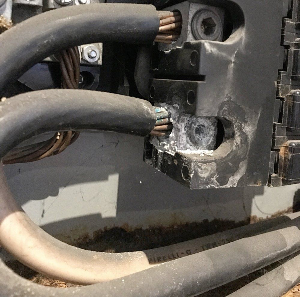 A broken electrical box with a bunch of wires coming out of it