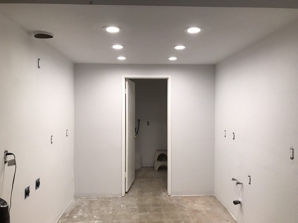 A room with white walls and a door that is being remodeled.
