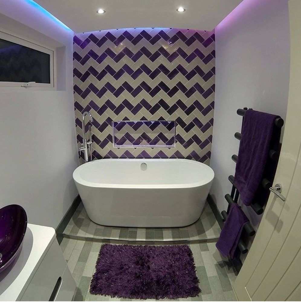 A bathroom with a bathtub and a purple rug