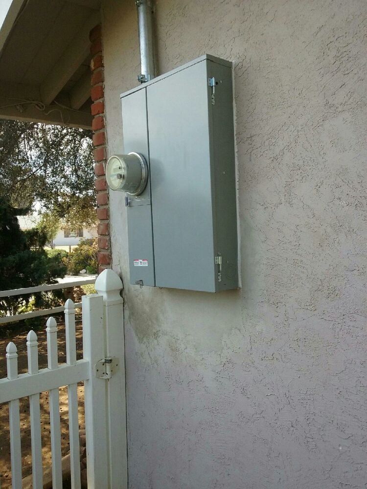 A white picket fence with a meter on the side of a building