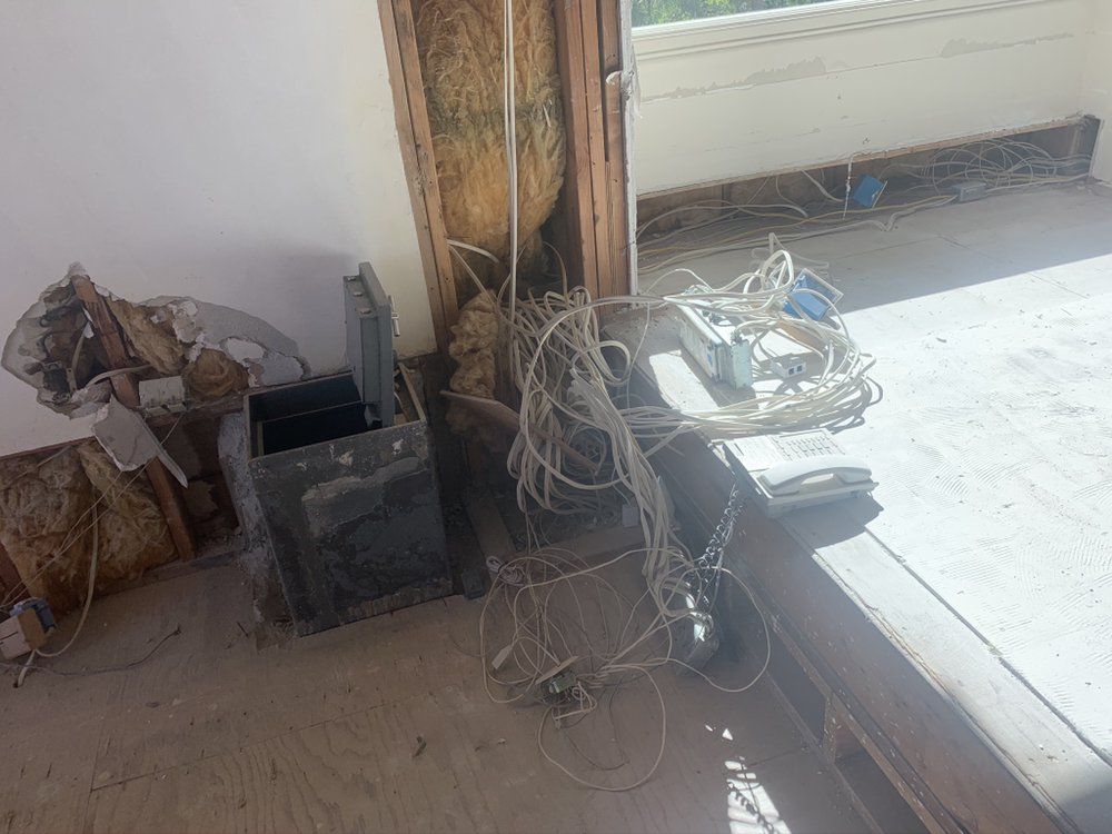 A bunch of wires are laying on the floor in a room.
