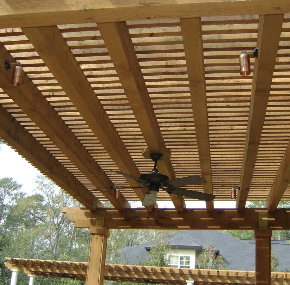 A wooden pergola with a ceiling fan and lights