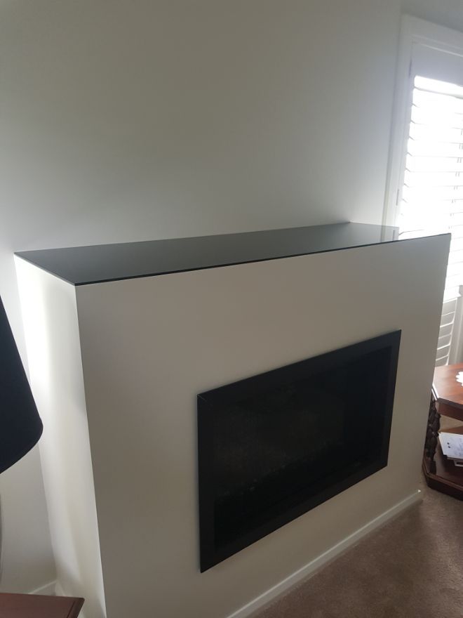 A Fireplace With a Flat Screen Tv Mounted on It in a Living Room — Moss Vale Glass In Moss Vale, NSW