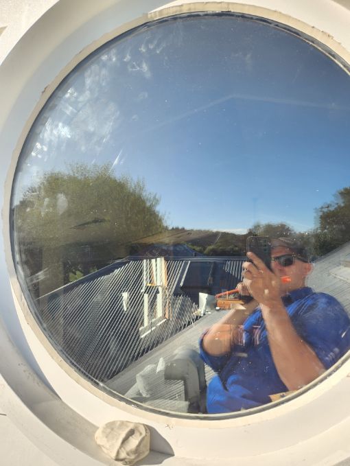 A man is taking a picture of himself in a round window