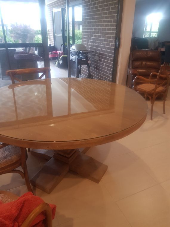 A Round Table With a Glass Top is in a Room With Chairs — Moss Vale Glass In Moss Vale, NSW