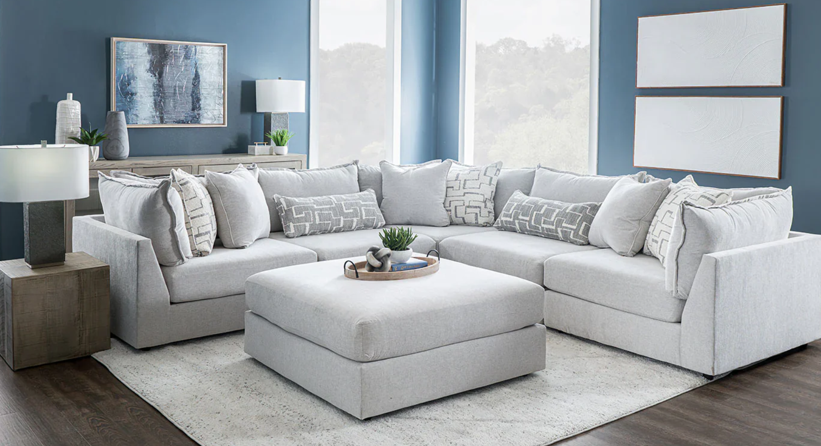 A living room with a large sectional couch and ottoman.