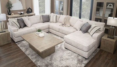 A living room with a large sectional couch and a coffee table.