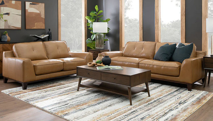 A living room with two brown leather couches , a coffee table , and a rug.