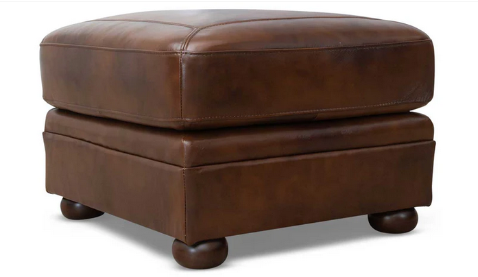 A brown leather ottoman with wooden legs on a white background.