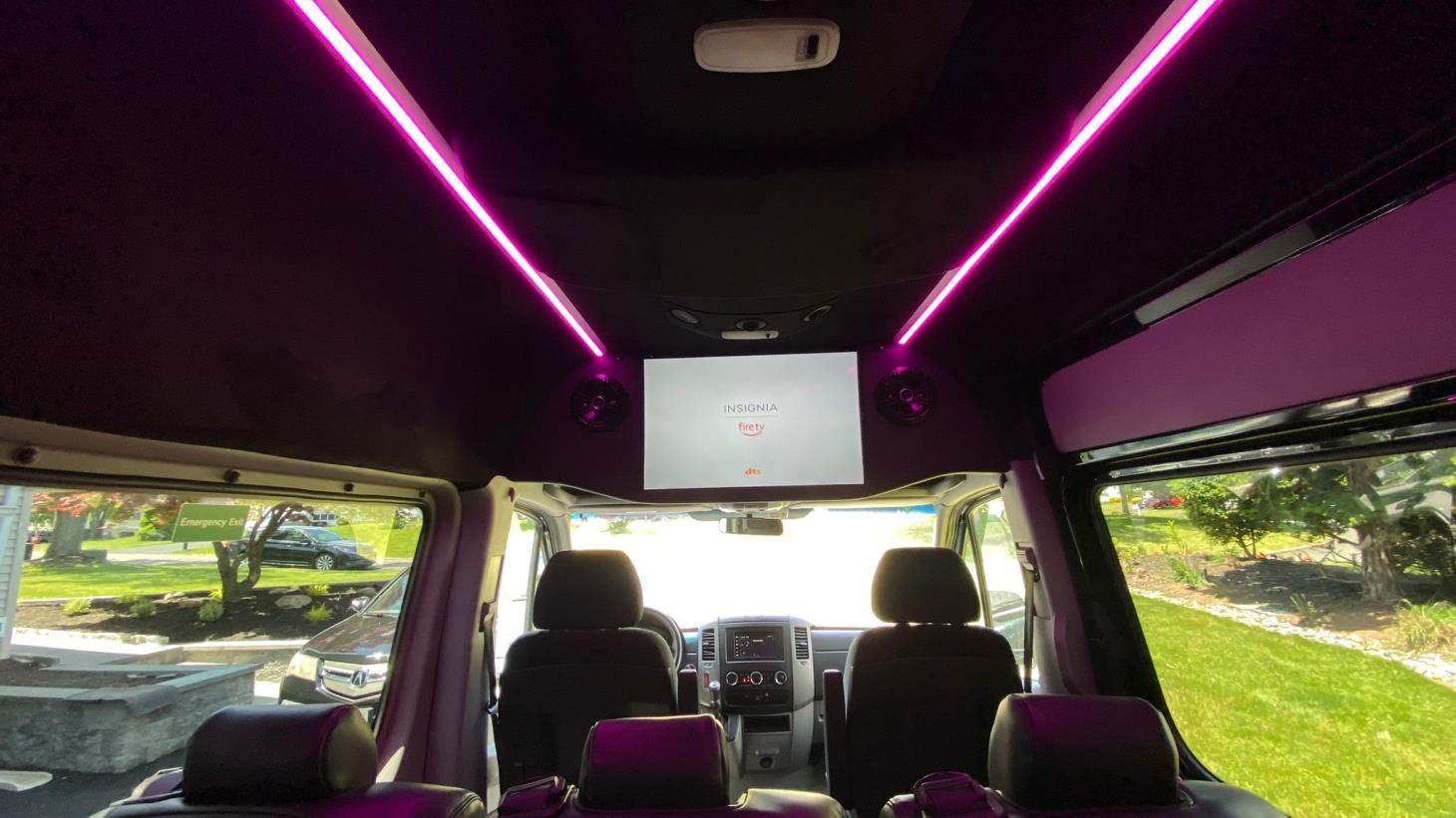 The inside of a van with a tv mounted to the ceiling.