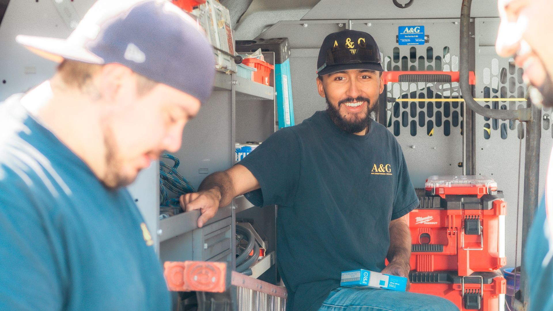 A & G Technicians are standing inside of a van.