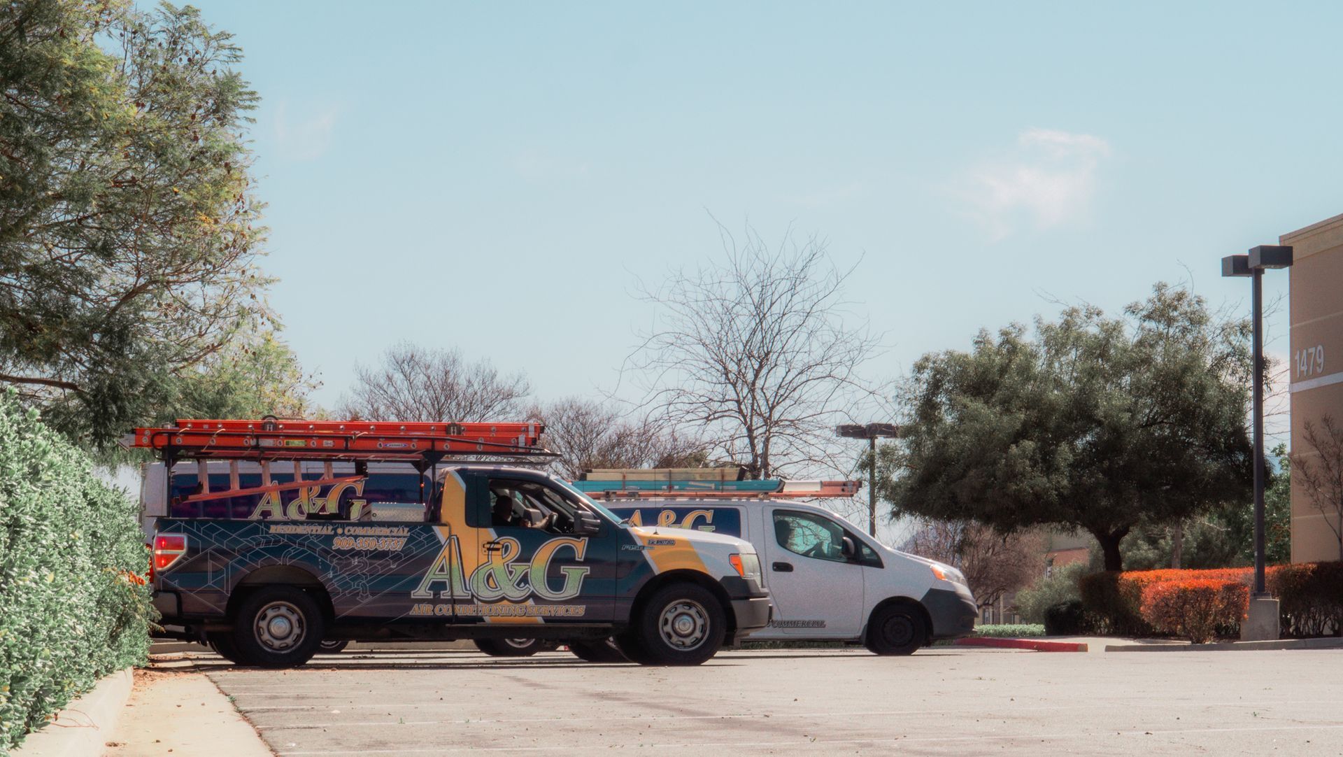 Two a & g trucks are parked in a parking lot.