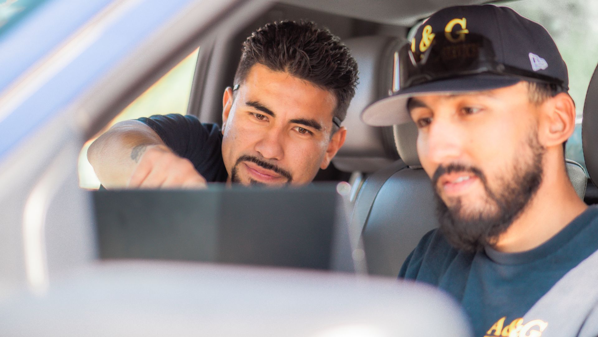 Two A & G Technician  are looking at a tablet in a car in San Bernardino County