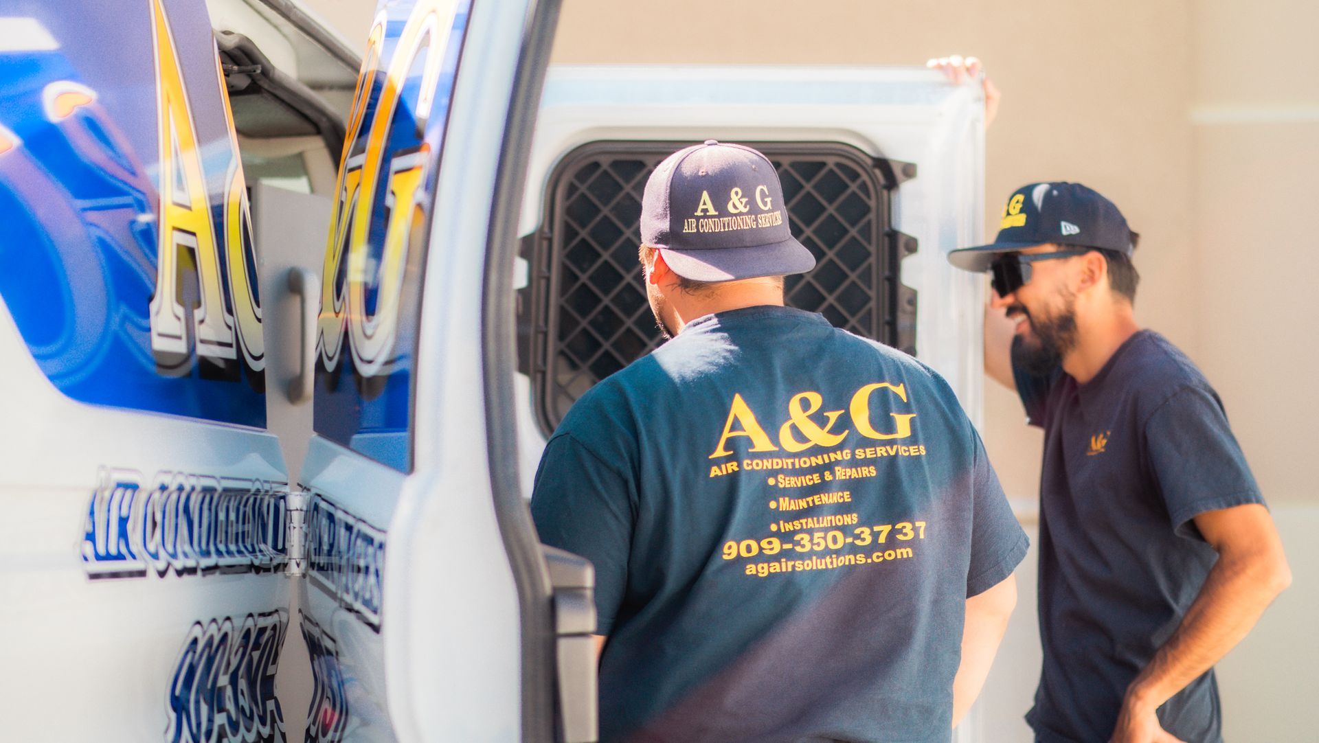 A & G Technicians  wearing a shirt that says a & g is getting out of a van in San Bernardino County.