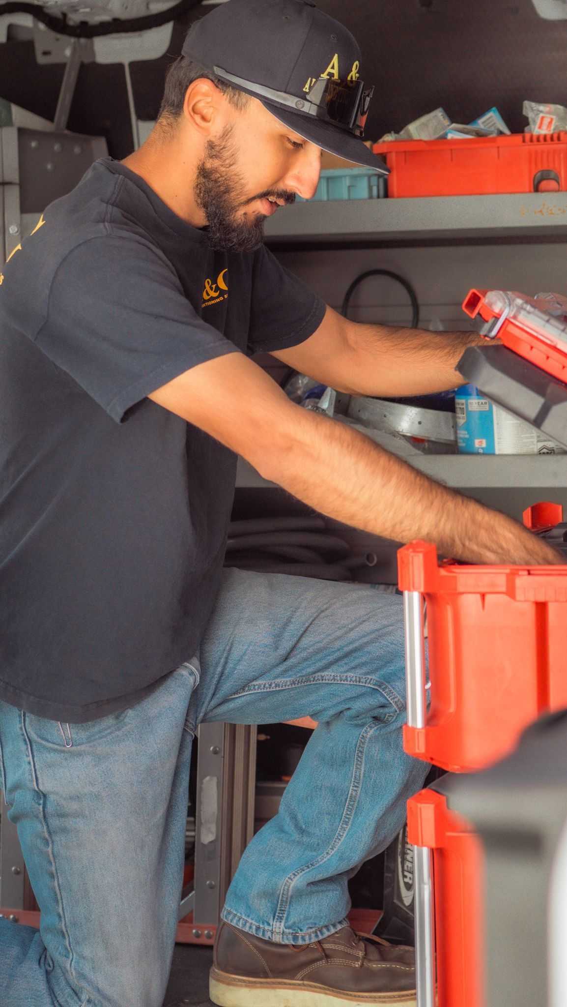 A & G Technician is kneeling down in a garage working on a toolbox.