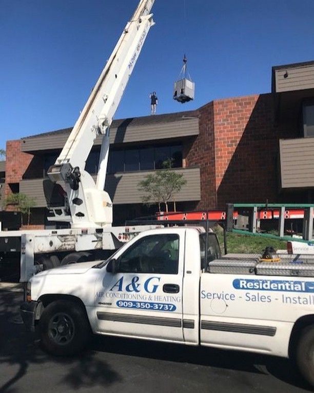 An A & G Air Conditioning work truck parked in front of a building in San Bernardino County.