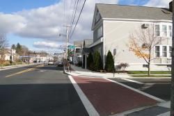 A house is sitting on the corner of a street next to a crosswalk.