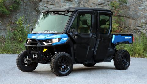 A blue and black utility vehicle is parked on the side of a road.