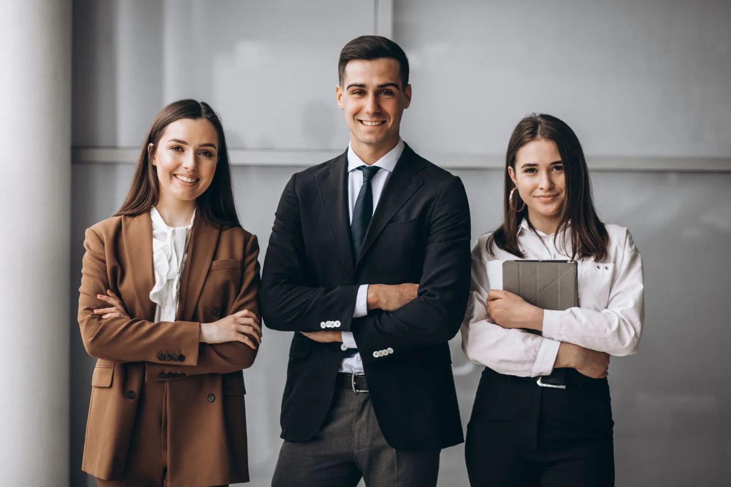 a man and two women are standing next to each other with their arms crossed