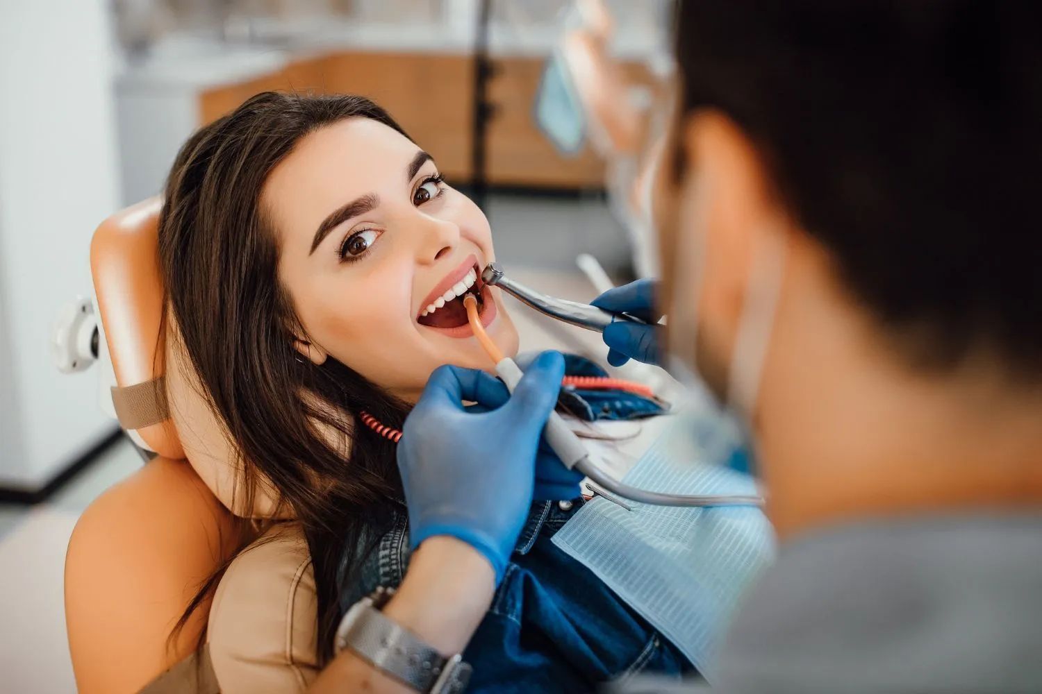 a woman is sitting in a dental chair while a dentist examines her teeth