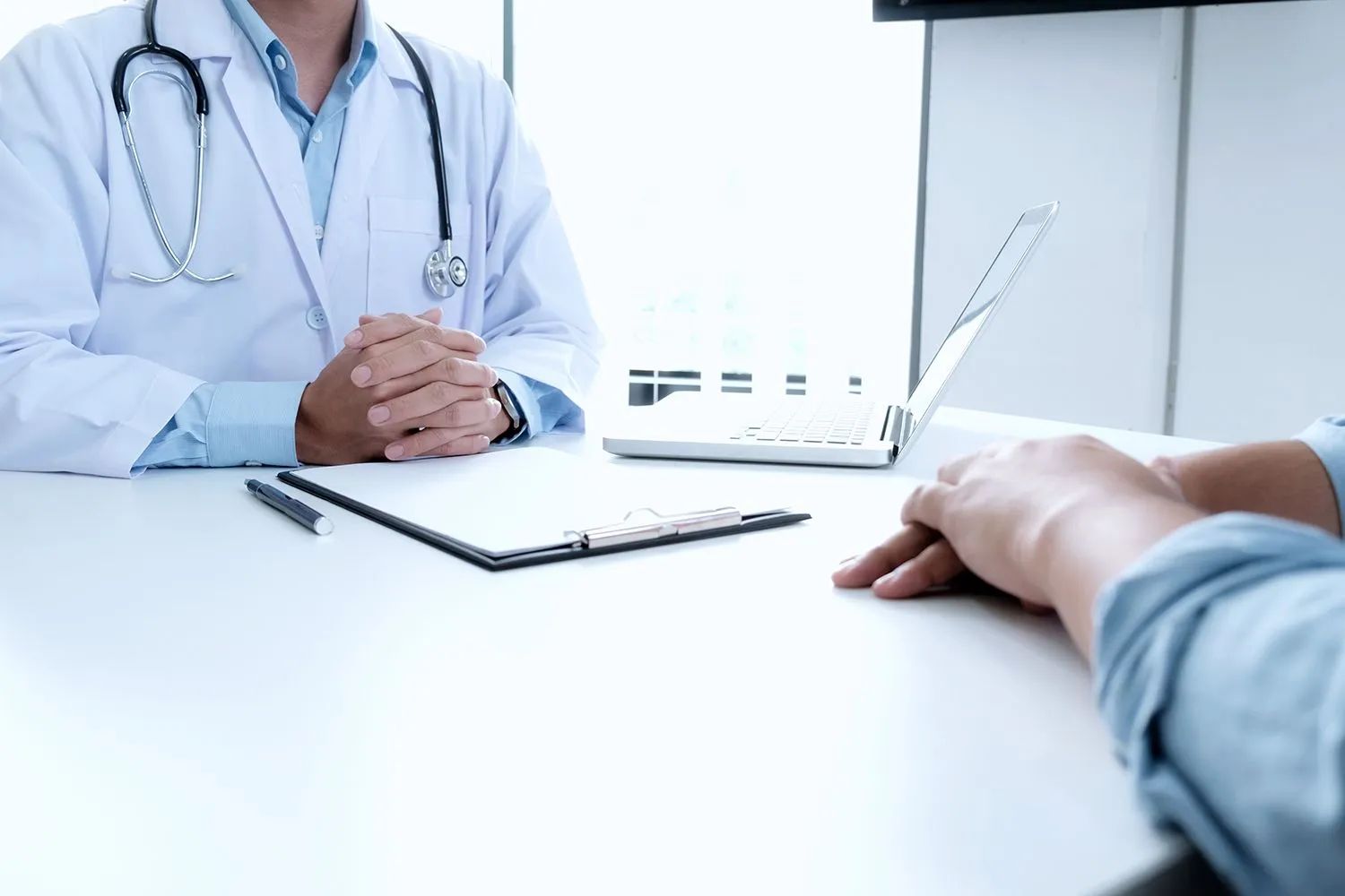 a doctor is sitting at a table talking to a patient