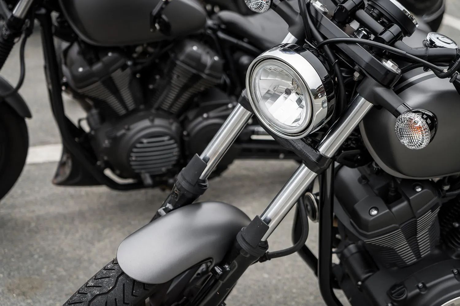 two black motorcycles are parked next to each other on the street