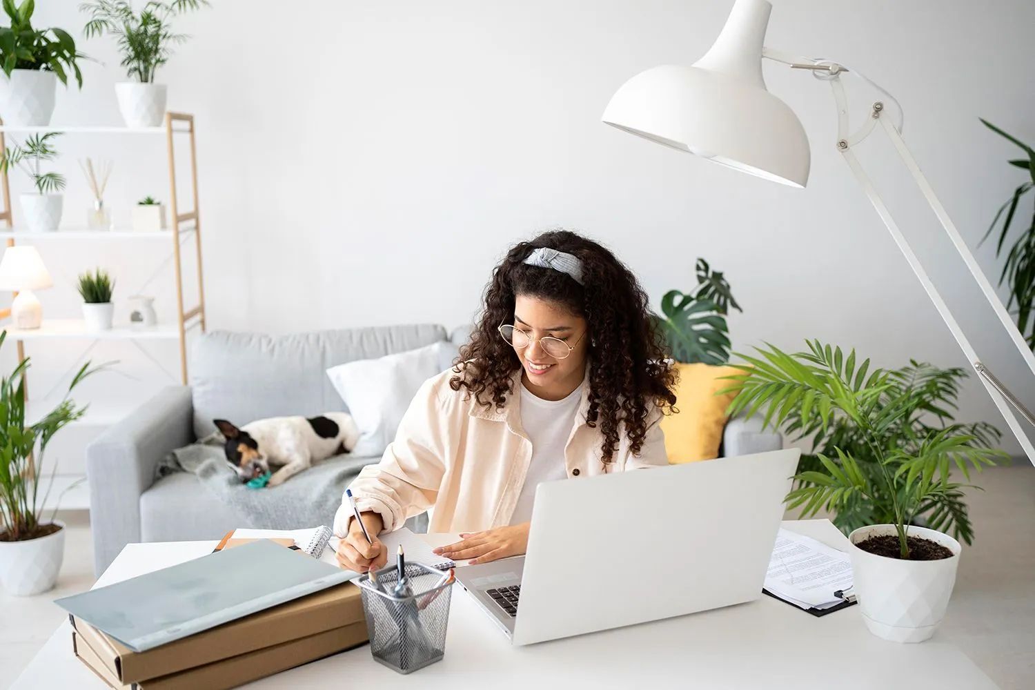 a woman is sitting at a desk using a laptop computer