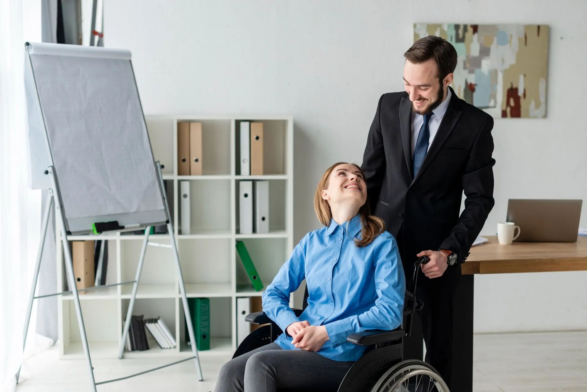 a man is standing next to a woman in a wheelchair