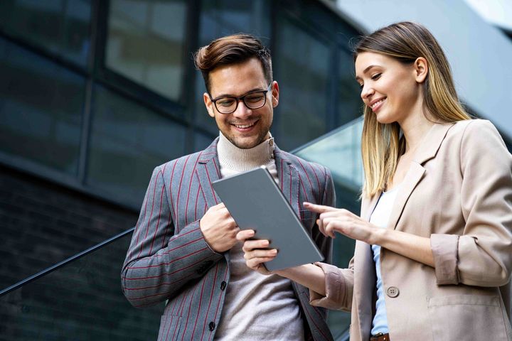 a man and a woman are looking at a tablet together