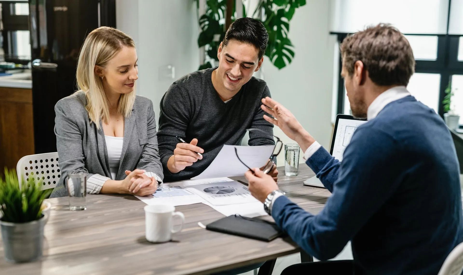 a man and a woman are sitting at a table talking to a man