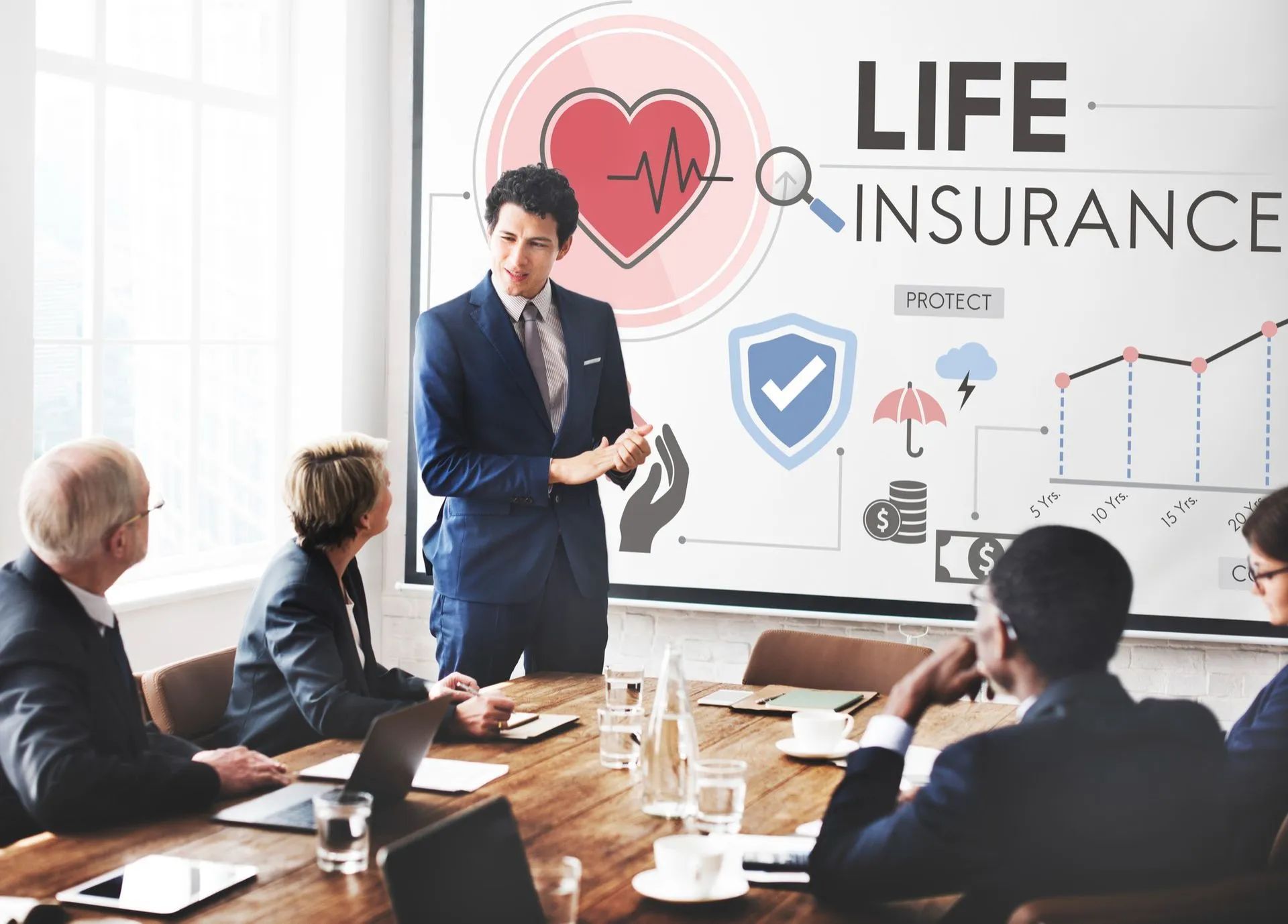 a man is giving a presentation to a group of people about life insurance