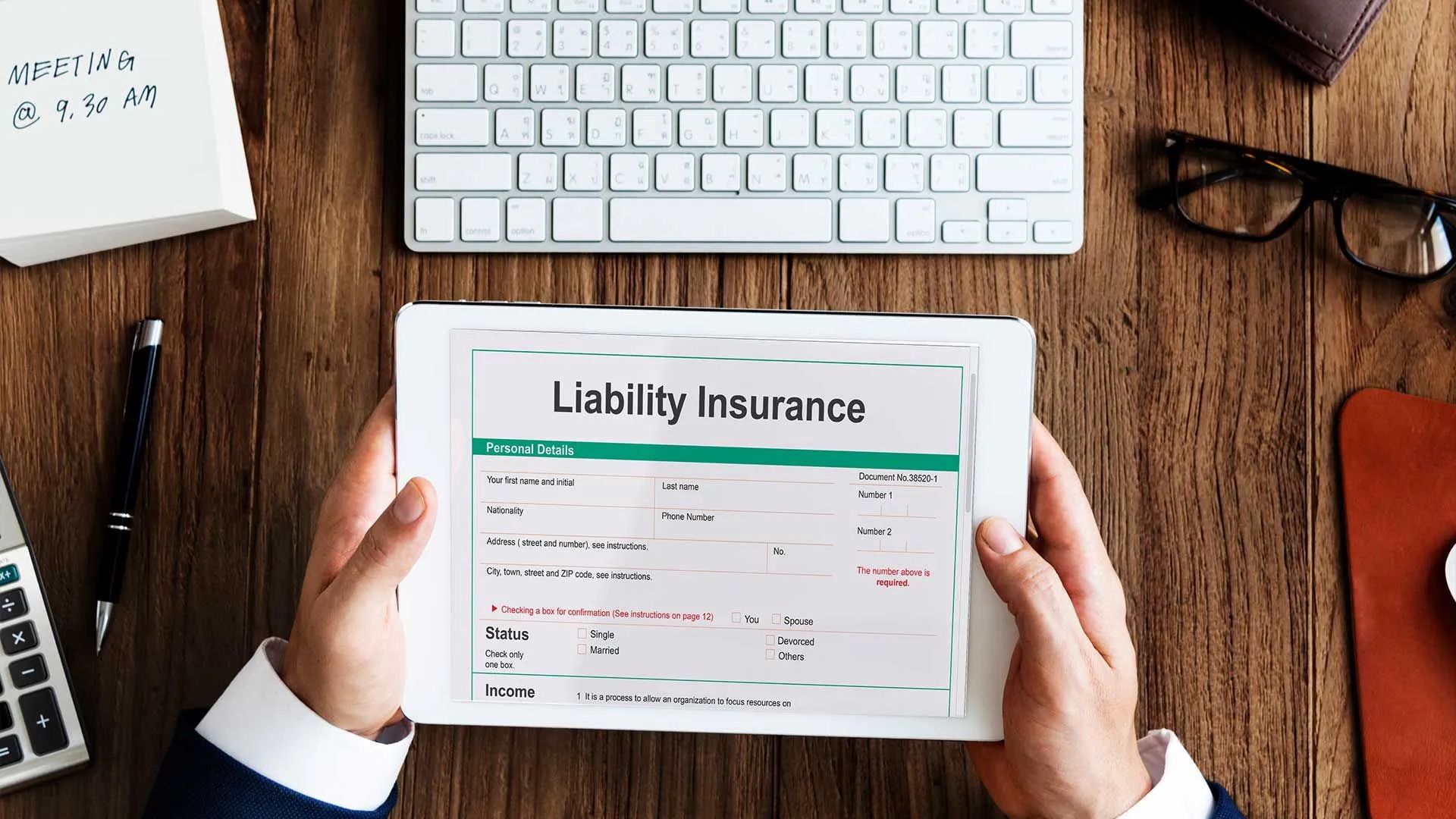 a person is holding a tablet with a liability insurance form on it