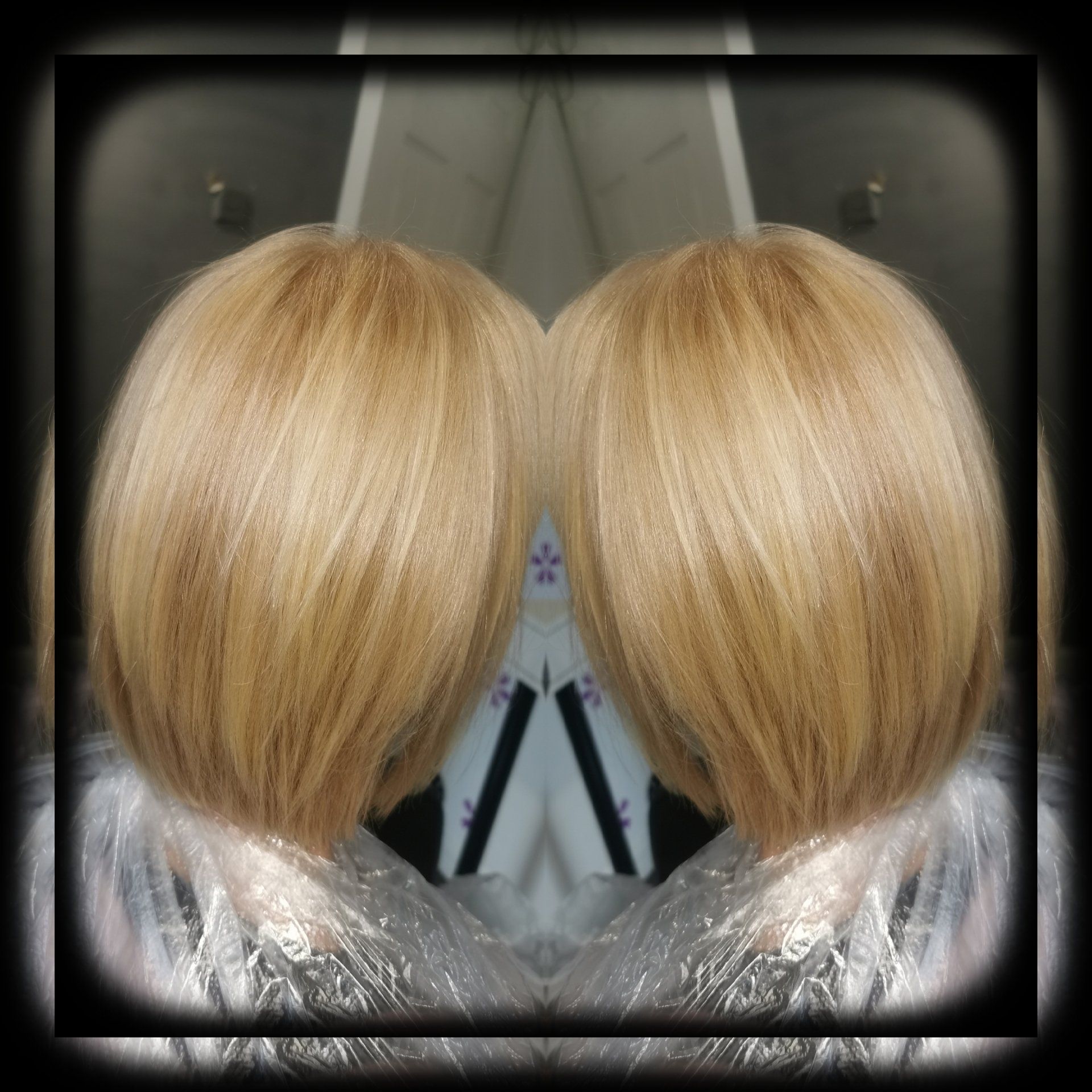 A woman 's blonde hair is reflected in a mirror