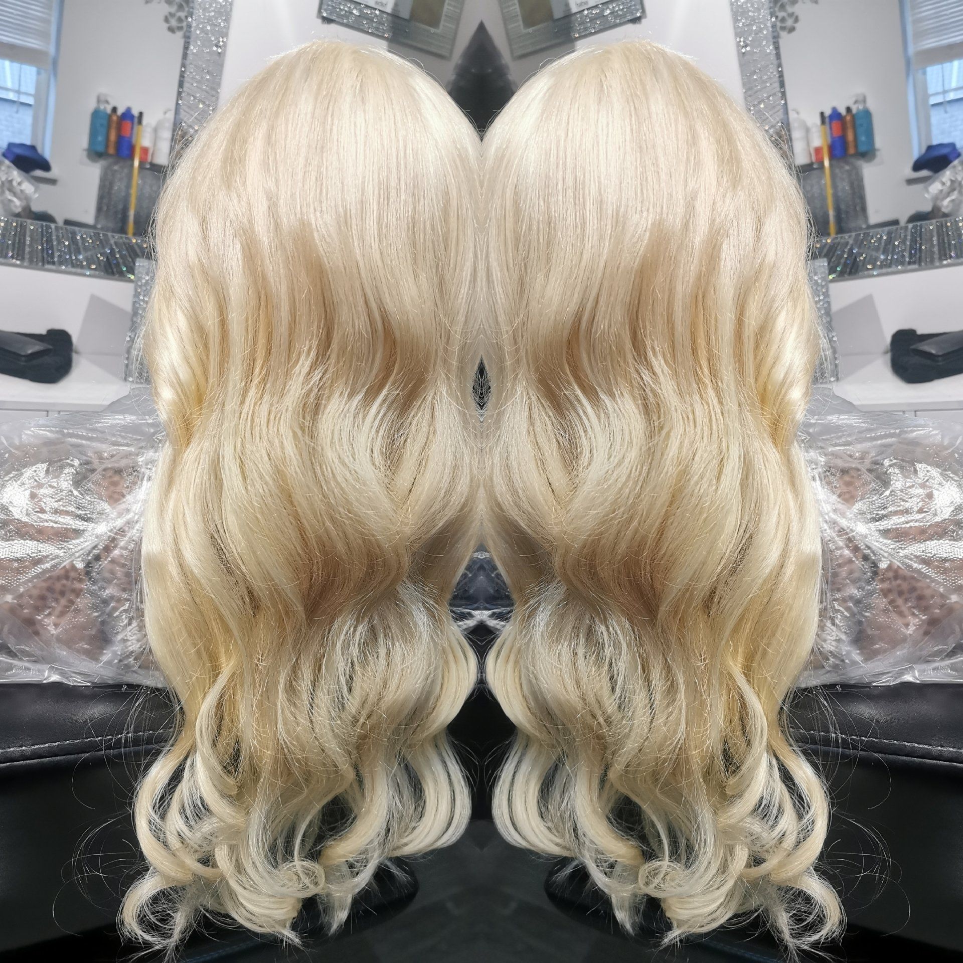 A woman 's blonde hair is reflected in a mirror