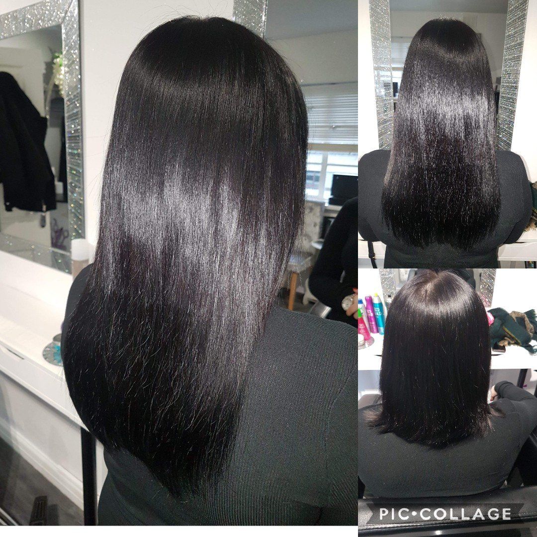 A woman with long black hair is sitting in front of a mirror.