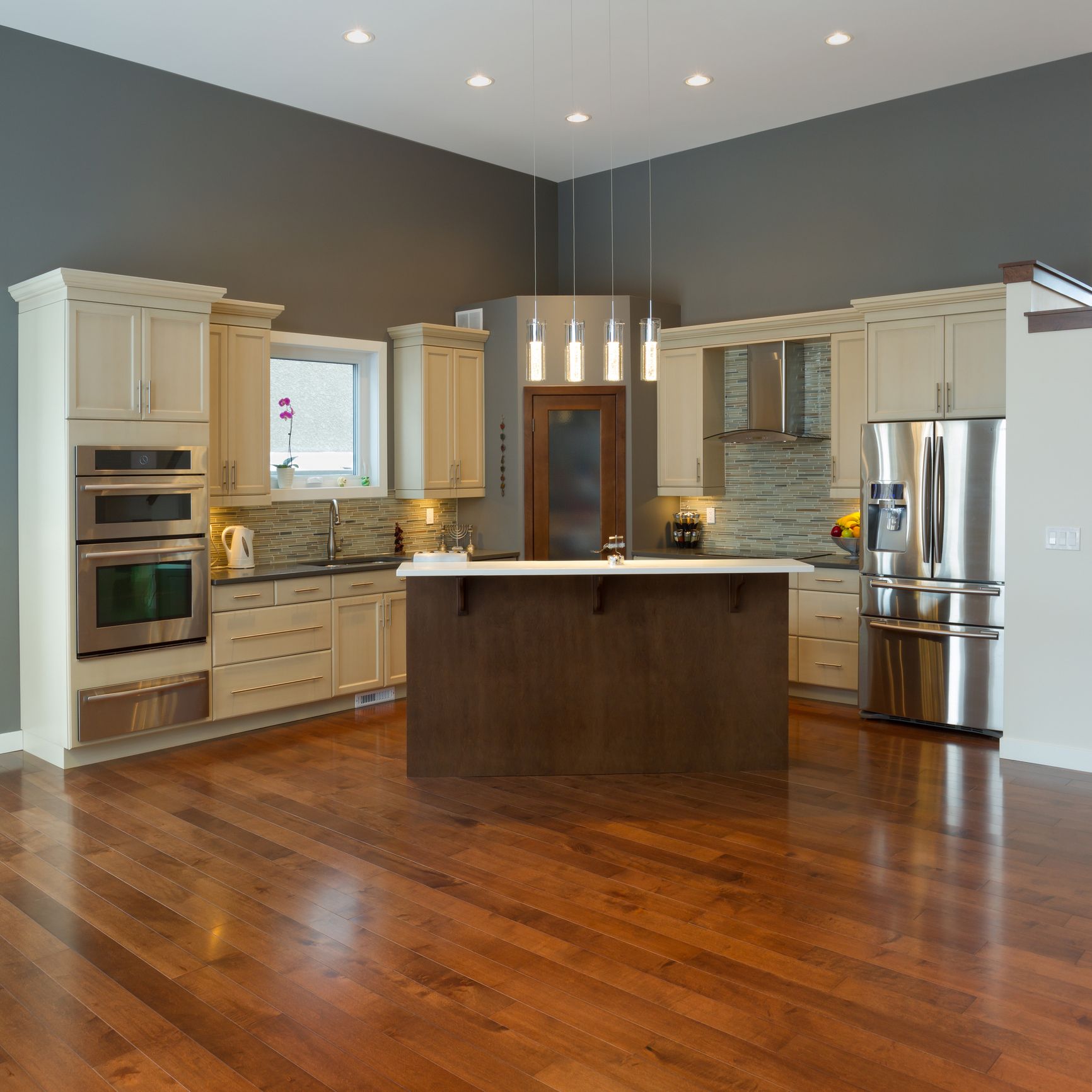 A kitchen with hardwood floors and stainless steel appliances