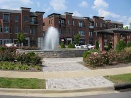 A large brick building with a fountain in front of it.