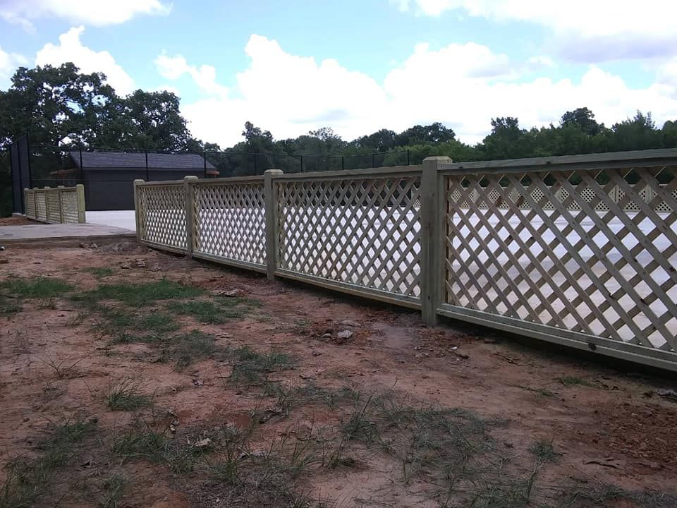 A wooden lattice fence with a garage in the background