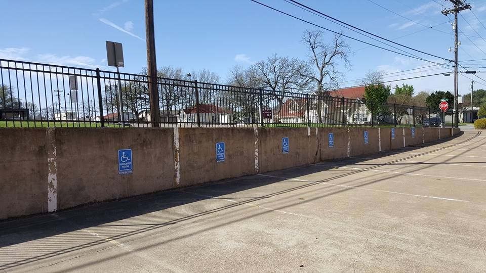 A concrete wall with handicapped parking signs painted on it.